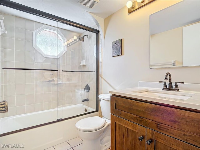 full bathroom with tile patterned floors, vanity, toilet, and bath / shower combo with glass door