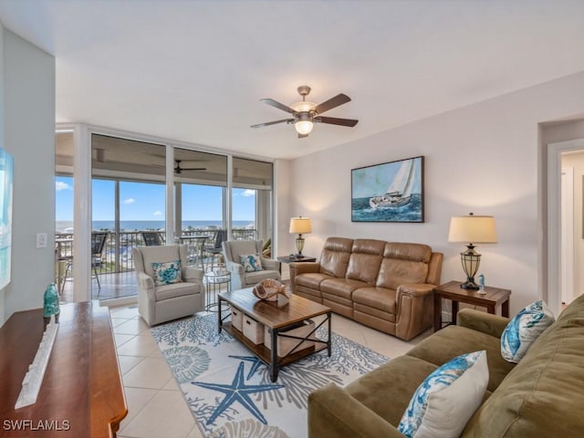 living room with ceiling fan, light tile patterned flooring, and a wall of windows