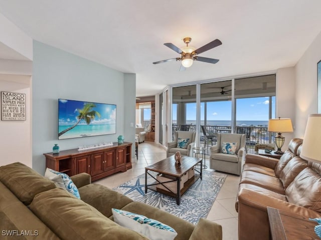 tiled living room with ceiling fan and a wall of windows