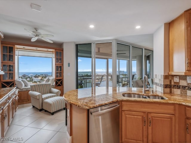 kitchen featuring decorative backsplash, ceiling fan, sink, a water view, and dishwasher