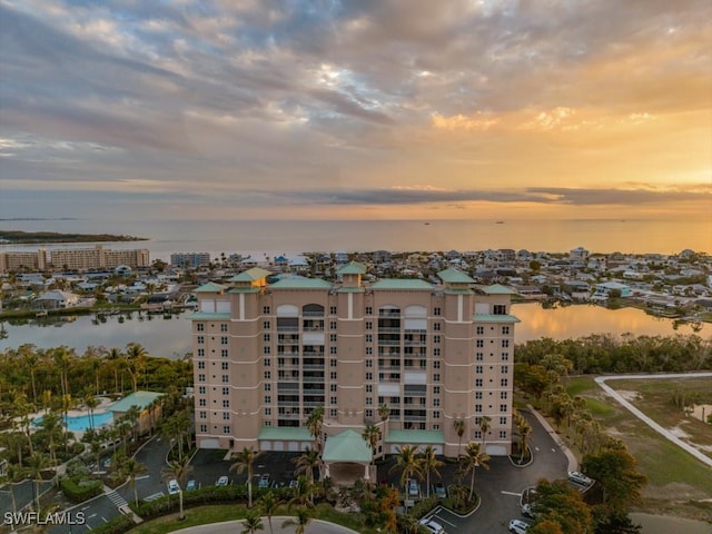 aerial view at dusk featuring a water view