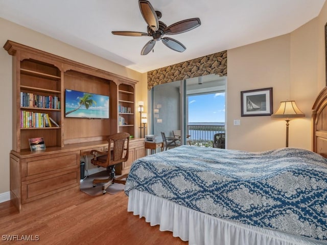 bedroom featuring access to exterior, ceiling fan, built in desk, and light hardwood / wood-style floors