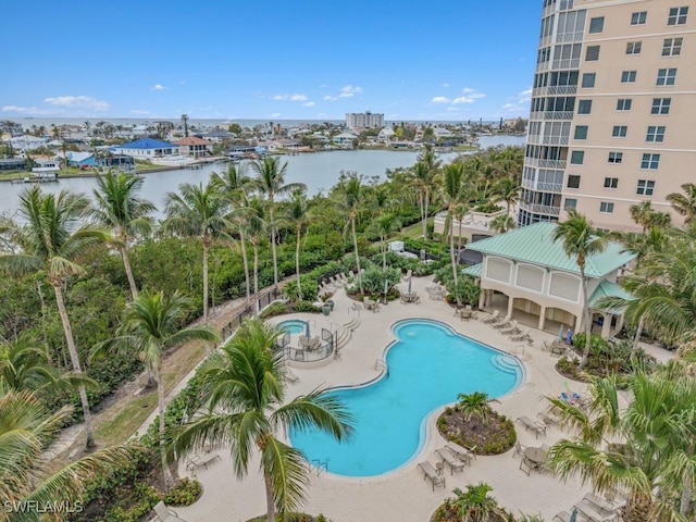 view of swimming pool featuring a water view and a patio