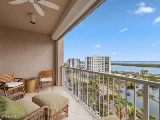 balcony with ceiling fan and a water view