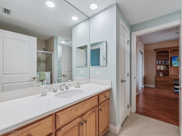 bathroom featuring tile patterned flooring, vanity, and walk in shower