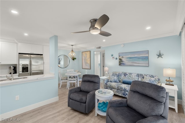 living room with crown molding, sink, ceiling fan, and light hardwood / wood-style floors