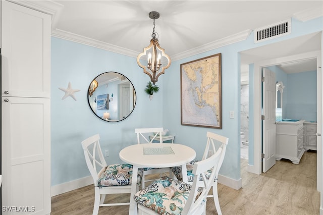 dining room with crown molding, light hardwood / wood-style flooring, and a chandelier