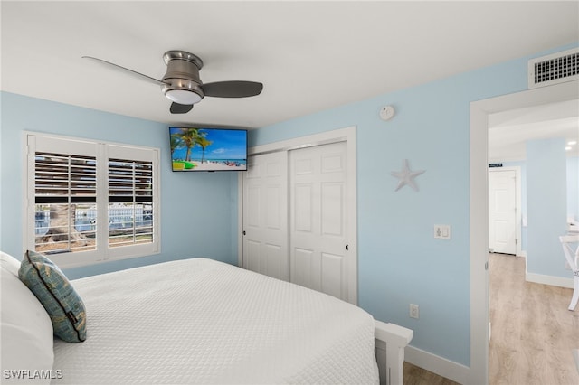 bedroom featuring ceiling fan, light hardwood / wood-style flooring, and a closet