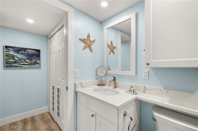 bathroom with vanity, toilet, and wood-type flooring