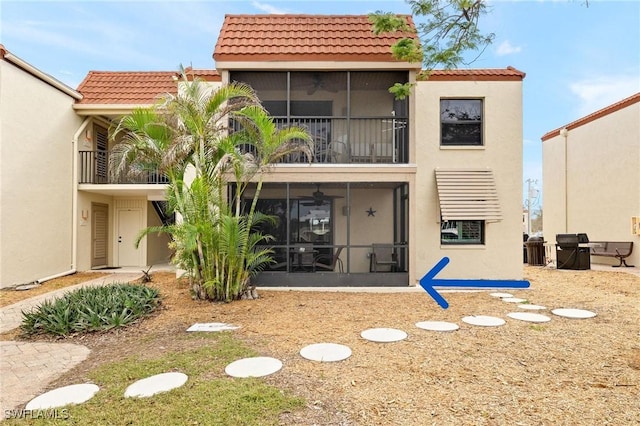 rear view of property featuring a sunroom