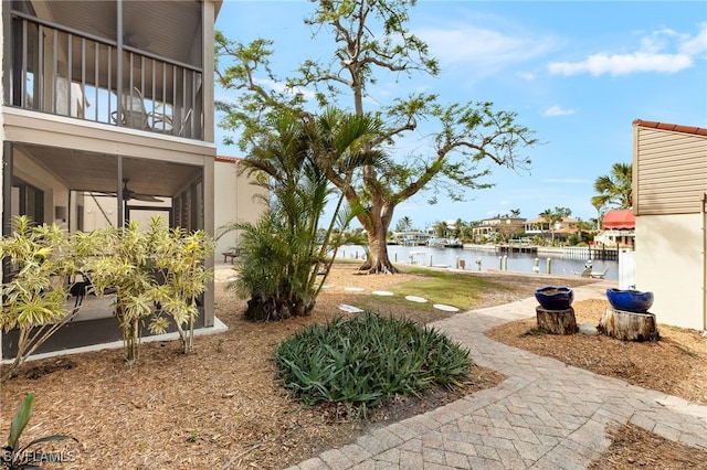 view of yard featuring a water view and a sunroom