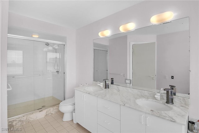 bathroom with tile patterned flooring, vanity, a shower with shower door, and toilet