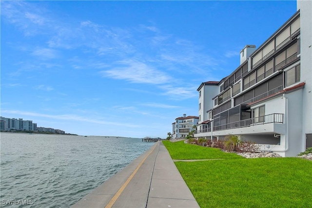 view of property's community featuring a yard and a water view