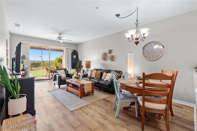 living room with light wood-style floors, baseboards, visible vents, and ceiling fan with notable chandelier