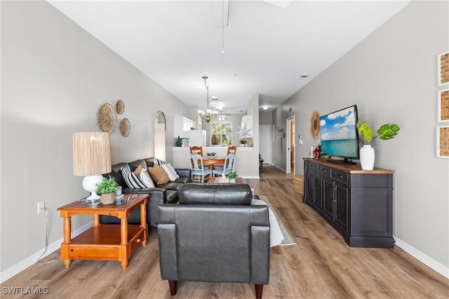 living room featuring light wood-type flooring and a chandelier