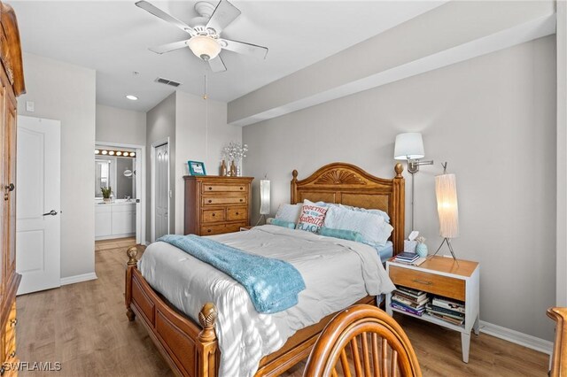 bedroom with ceiling fan, connected bathroom, light hardwood / wood-style flooring, and a closet