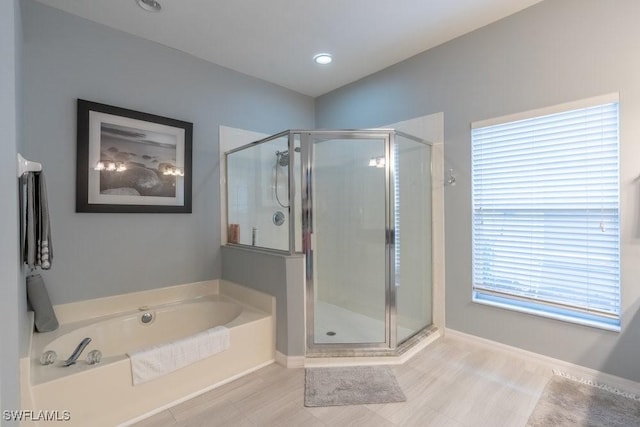 bathroom featuring shower with separate bathtub