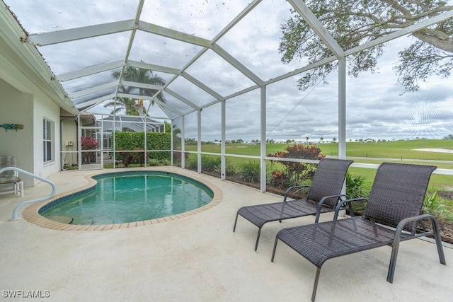 view of pool with glass enclosure and a patio