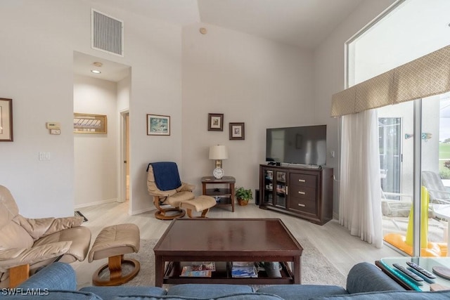 living room with a high ceiling and light wood-type flooring