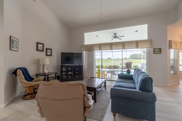 living room featuring ceiling fan, light hardwood / wood-style flooring, and high vaulted ceiling