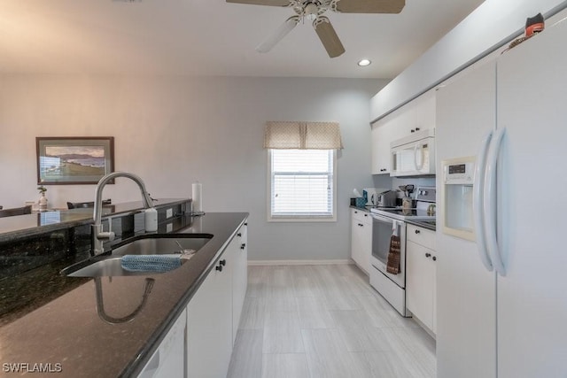 kitchen featuring dark stone counters, white appliances, ceiling fan, sink, and white cabinetry