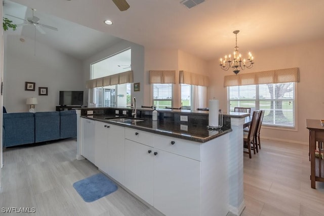 kitchen with sink, pendant lighting, a center island with sink, white cabinets, and ceiling fan with notable chandelier