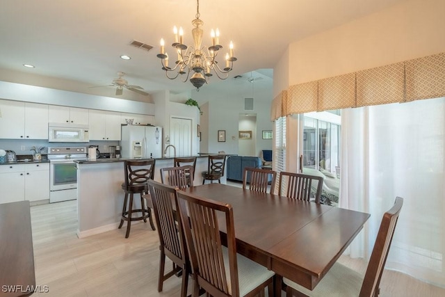 dining area with light hardwood / wood-style floors and ceiling fan with notable chandelier