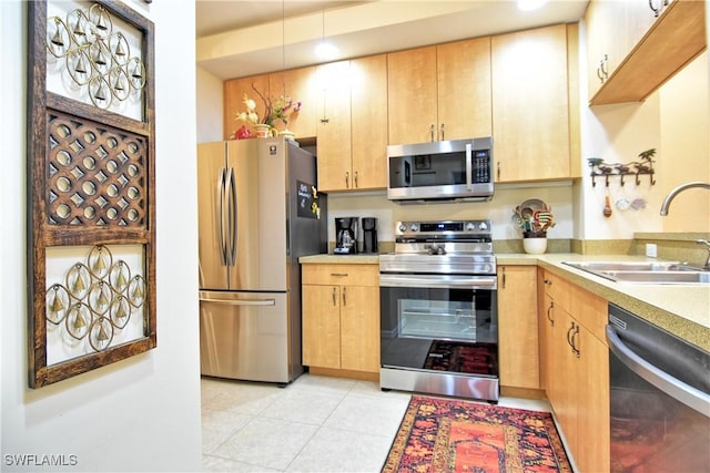 kitchen with sink, light tile patterned floors, and appliances with stainless steel finishes