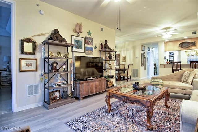 living room with light hardwood / wood-style floors and ceiling fan