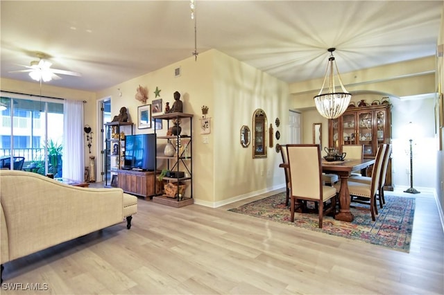 dining room featuring light hardwood / wood-style floors and ceiling fan with notable chandelier