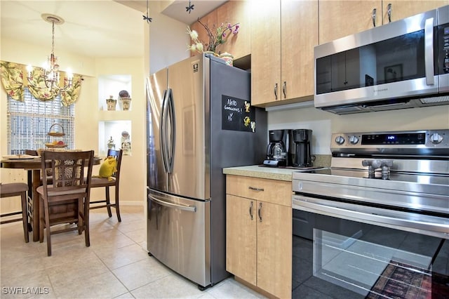 kitchen with light brown cabinetry, pendant lighting, stainless steel appliances, and a notable chandelier