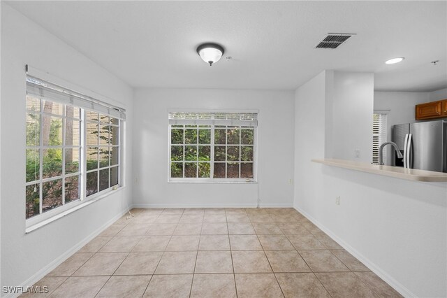 unfurnished dining area with sink and light tile patterned floors