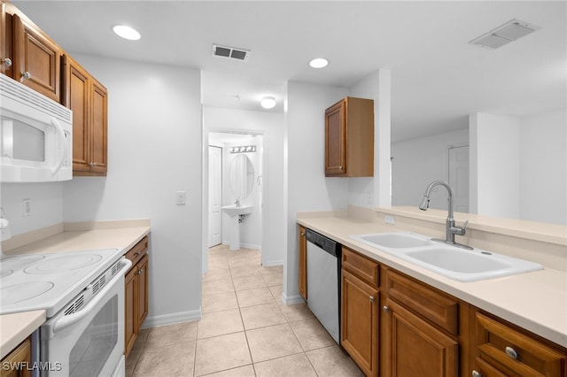 kitchen with light tile patterned floors, white appliances, and sink