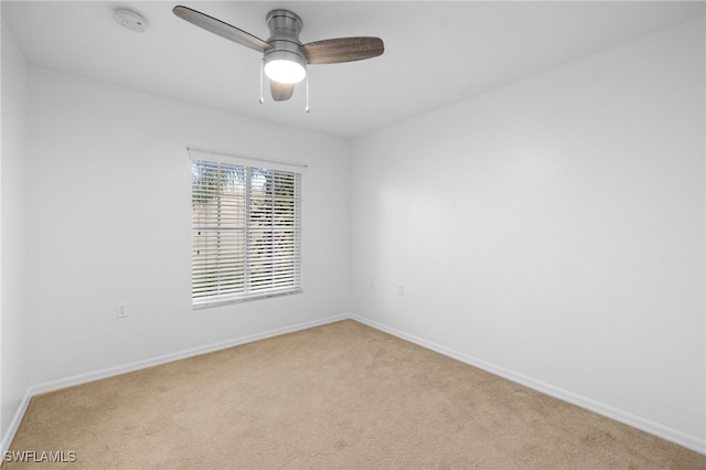 carpeted spare room featuring ceiling fan