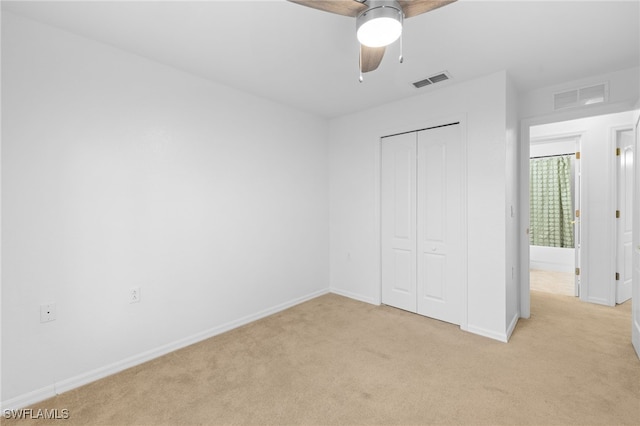 unfurnished bedroom with ceiling fan, a closet, and light carpet