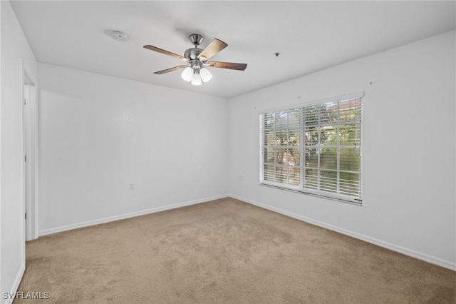 carpeted empty room featuring ceiling fan