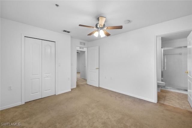 unfurnished bedroom with ceiling fan, ensuite bathroom, light colored carpet, and a closet