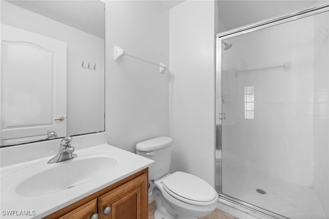 bathroom featuring vanity, a shower with shower door, and toilet