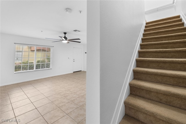 staircase with tile patterned floors and ceiling fan