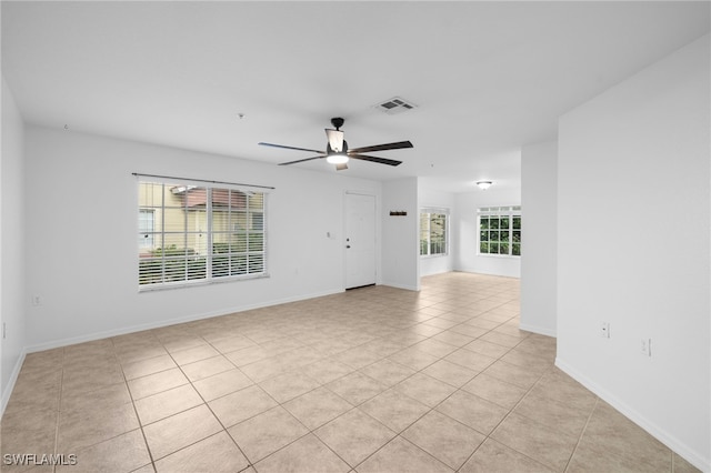 empty room with ceiling fan and light tile patterned floors