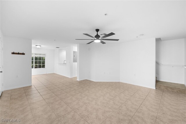 tiled spare room with ceiling fan