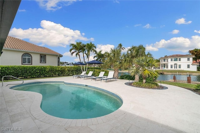 view of pool featuring a patio area, a fenced in pool, and a water view