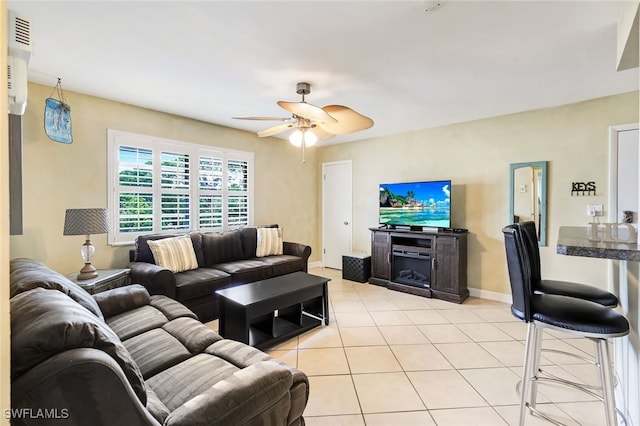 tiled living room featuring ceiling fan and a fireplace