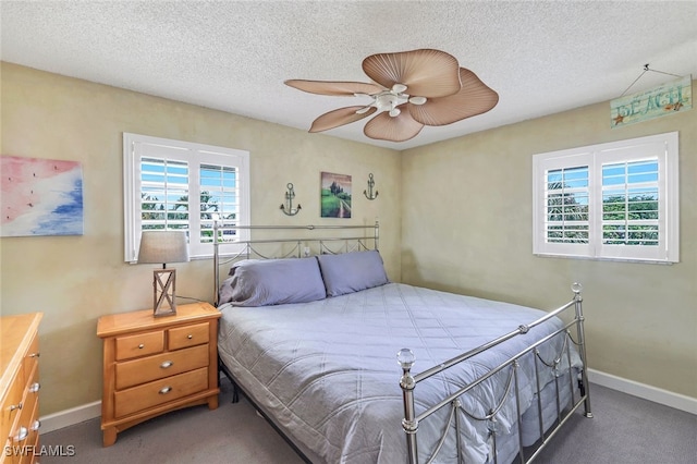 carpeted bedroom featuring multiple windows, a textured ceiling, and ceiling fan