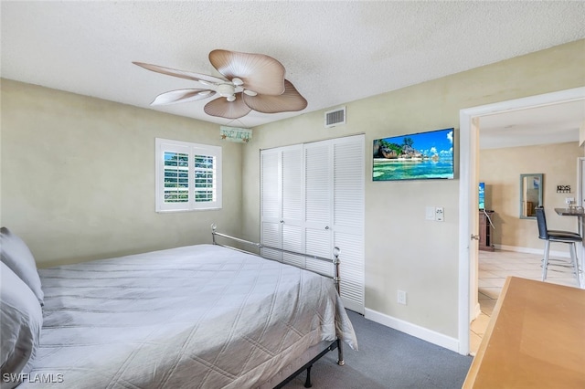 bedroom with light carpet, a textured ceiling, a closet, and ceiling fan