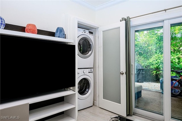 washroom with stacked washer / drying machine, light hardwood / wood-style floors, and crown molding