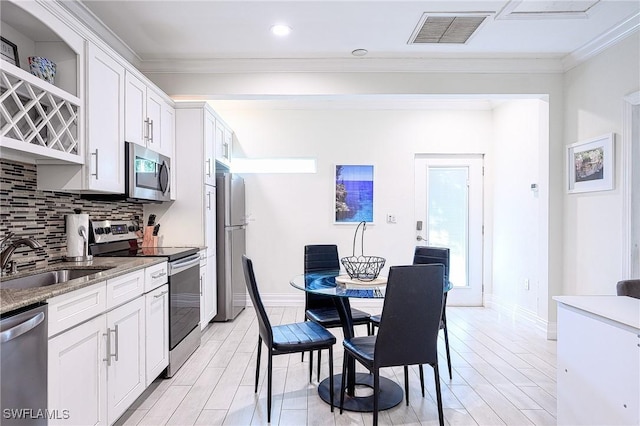 kitchen with dark stone countertops, sink, white cabinets, and appliances with stainless steel finishes