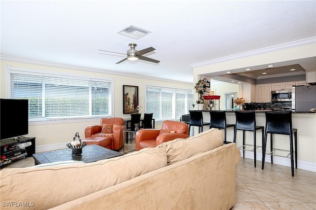 living room featuring light tile patterned floors, ceiling fan, and ornamental molding