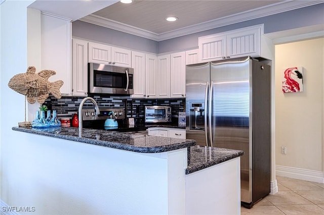 kitchen featuring kitchen peninsula, decorative backsplash, white cabinets, and stainless steel appliances