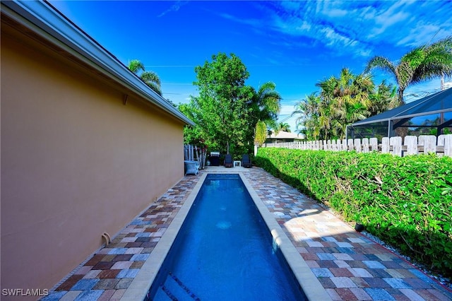 view of swimming pool with glass enclosure